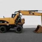 Caterpillar M318D wheeled excavator in side profile showing four road wheels, boom and digging bucket