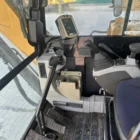 Caterpillar 305.5E2 cab controls with joysticks, foot pedals and side display panel